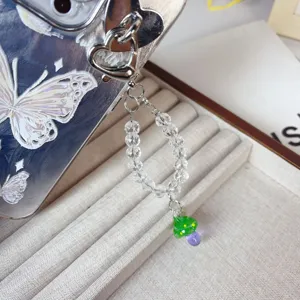 Crystal beaded phone charm detail shot, featuring a cute green mushroom pendant and heart link.