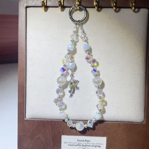 Detailed view of handmade crystal beaded phone charm with shooting star pendant, shiny.
