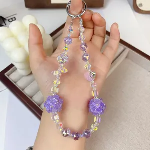Detailed close-up of purple beaded phone charm, crystal rose ball design, elegant accessory pendant.