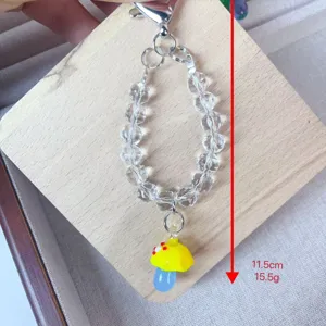 Crystal beaded phone charm with handmade yellow mushroom pendant, short strap accessory.