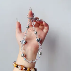 Handmade crystal beaded phone charm wrist strap with alloy hearts for women luxury decor.