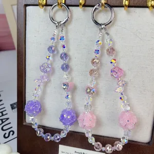 Detail shot of sparkling crystal beaded phone charms and bag keychains with rose flower balls.