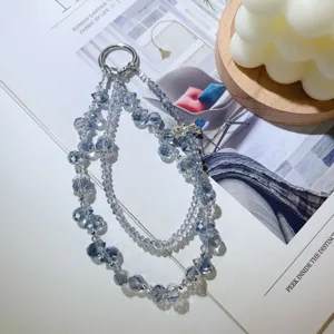 Gros plan détaillé d'un bracelet en perles de cristal bleu scintillant avec nœud et anneau.