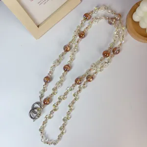 Detailed view of sparkly crystal flower bead phone lanyard with amber charms and metal rings.