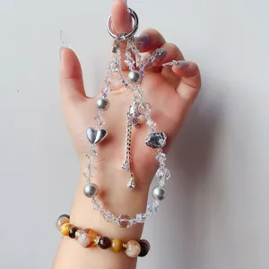 Handmade crystal beaded phone charm wrist strap with silver heart and pearls for women.
