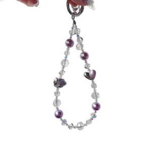 Handmade crystal beaded phone charm with purple pearls and cute heart alloy pendant for women.
