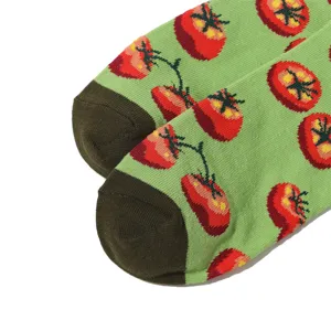 Nahaufnahme von Retro Tomaten Druck Baumwoll Socken in Grün mit dunkler Fersenpartie.