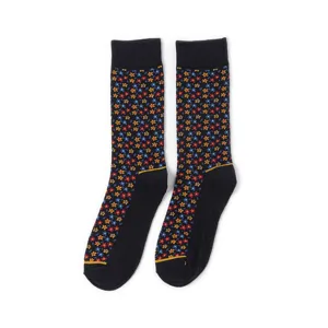 Detailaufnahme schwarzer Crew-Socken mit buntem Mikro-Blumenmuster und Rippbündchen.