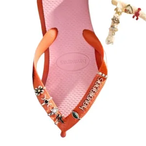 Modieuze DIY teenslipper met stijlvolle metalen bedels voor zomerse strandoutfits.