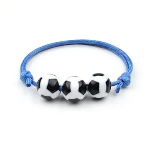 Vista dettagliata di un elegante bracciale in corda intrecciata blu con tre perline da calcio.