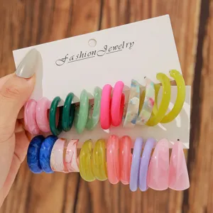 Colorful resin C-shaped hoop earrings set on a display card for daily fashion wear styles.