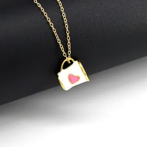 Détail rapproché d'un mignon collier avec pendentif tasse de café et un cœur rose.