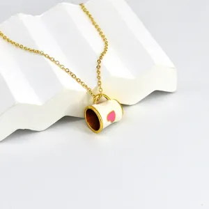 Détail de collier pendentif tasse émaillée mignon, chaîne dorée avec pendentif cœur rose.