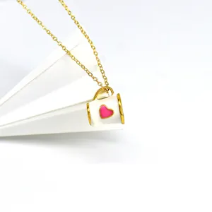 Collier chaîne dorée avec un joli pendentif tasse blanche et son cœur rose.