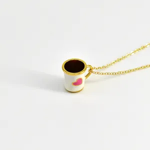 Détail en gros plan d'un joli collier pendentif tasse à café en émail cœur rose.