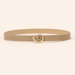 Detail view of women belt with gold tone shell buckle, beige PU leather, elegant accessory.