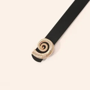 Close-up of women's black leather belt featuring unique gold spiral metal buckle.