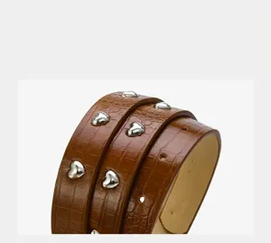 Detailed close-up view of a brown crocodile pattern PU leather belt with silver heart rivets.