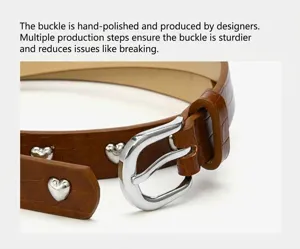 Close-up of women's crocodile pattern leather belt with silver heart rivets and polished buckle.