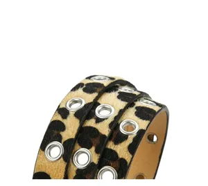 Gros plan sur la ceinture en cuir PU imprimé léopard, œillets métalliques et texture.