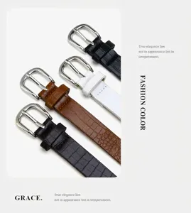 Close-up detail shot of women crocodile pattern thin leather belt with stylish silver buckle.