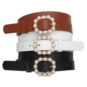 Detailed shot of stackable leather belts featuring elegant pearl buckle designs in three classic colors.