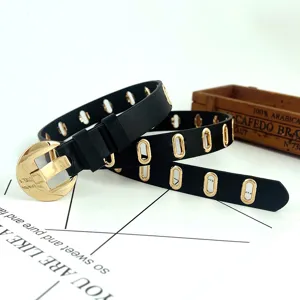 Ceinture femme noire en cuir synthétique avec boucle ronde dorée et œillets tendance.