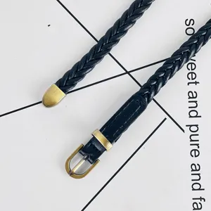 Ceinture fine tressée noire pour femme avec boucle rétro en laiton et embout en métal.