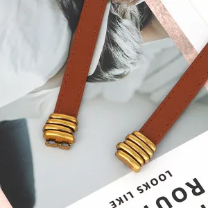 Smalle bruine lederen riem voor dames, vintage gouden metalen details, stijlvol accessoire.