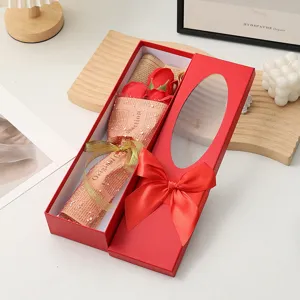 Close-up detail of a romantic red soap rose gift box with a clear window and elegant ribbon bow.