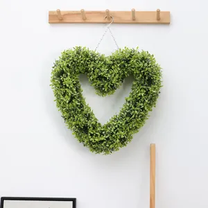 Artificial boxwood heart wreath detail, 3D hanging green plant decor for live streaming background.
