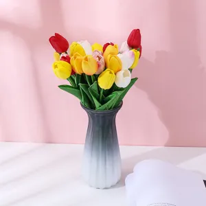 Gros plan de tulipes artificielles colorées dans un vase dégradé pour la décoration intérieure.