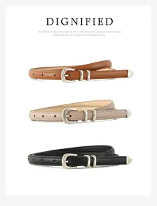 Close up detail of slim leather belt featuring a refined silver buckle and classic thin strap.