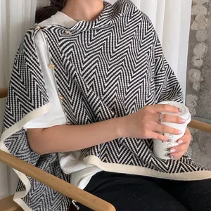 Black and white chevron knit shawl detail, stylish patterned poncho cape for women autumn winter fashion.