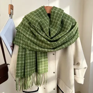 Close-up detail of the green plaid winter scarf draped neatly with a stylish beige coat layer.