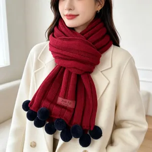 Cozy winter knitted scarf for women, featuring plush pom-pom accents and thick warm design.