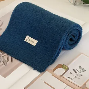 Detailed view of solid color knitted cross scarf for women autumn and winter cozy wear.