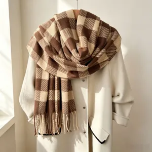 Gros plan détaillé d'une écharpe d'hiver à carreaux marron et beige avec de jolies franges.