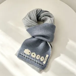 Vista dettagliata della sciarpa in maglia jacquard con pecora, comodo accessorio invernale.