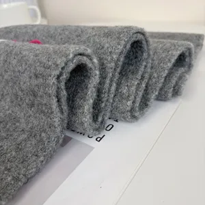 Grey knitted winter scarf texture detail, soft warm woolen neck wrap with cute bow accent.