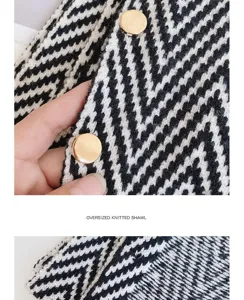 Close-up detail of black and white chevron knit shawl with golden buttons, cozy texture.