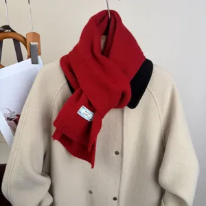 Primo piano di una sciarpa lavorata a maglia rossa vivace per inverno, calda e morbida.