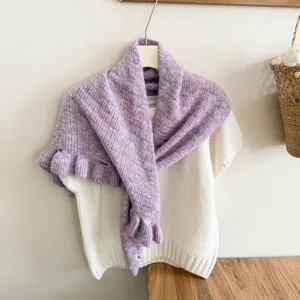 Detailed shot of women's knitted ruffle shawl and sweater set, cozy and versatile style.
