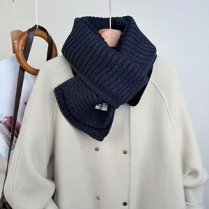 Primo piano dettagliato della sciarpa in maglia accogliente in tonalità scura, accessorio chic.