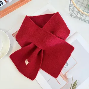 Red knitted crisscross scarf detail, cozy winter wool neck warmer, stylish minimalist accessory.