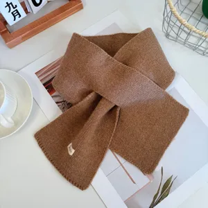 Stylish solid color cross knitted scarf for women, cozy winter warm brown neck warmer detail.