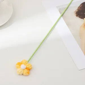 Gros plan détaillé d'une fleur bouffante en laine crochetée à la main avec tige.