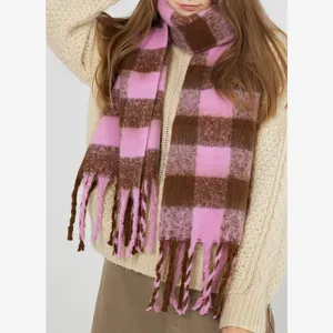 Close-up detail of cozy pink and brown plaid mohair scarf with thick fringe tassels.