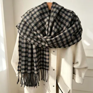 Close-up view of a vintage plaid patterned winter scarf with delicate tassel details.