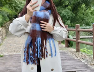 Detailed close-up view of the blue and brown plaid mohair fringe winter scarf outdoors.